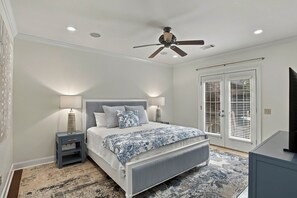 A bedroom with a bed, nightstands, a ceiling fan, and a view through the window. - War Eagle Manor:Your Auburn Getaway (Auburn)