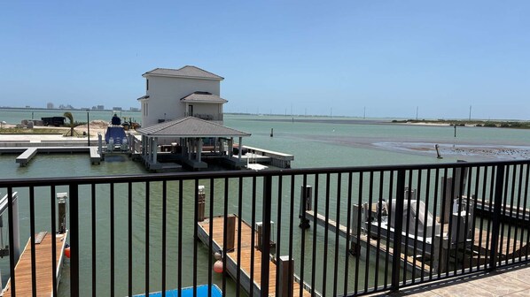 Una propiedad frente al agua con muelle, una construcción pequeña y una vista despejada del agua.