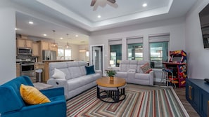 A modern living room with a sofa, a coffee table, and a blue armchair.