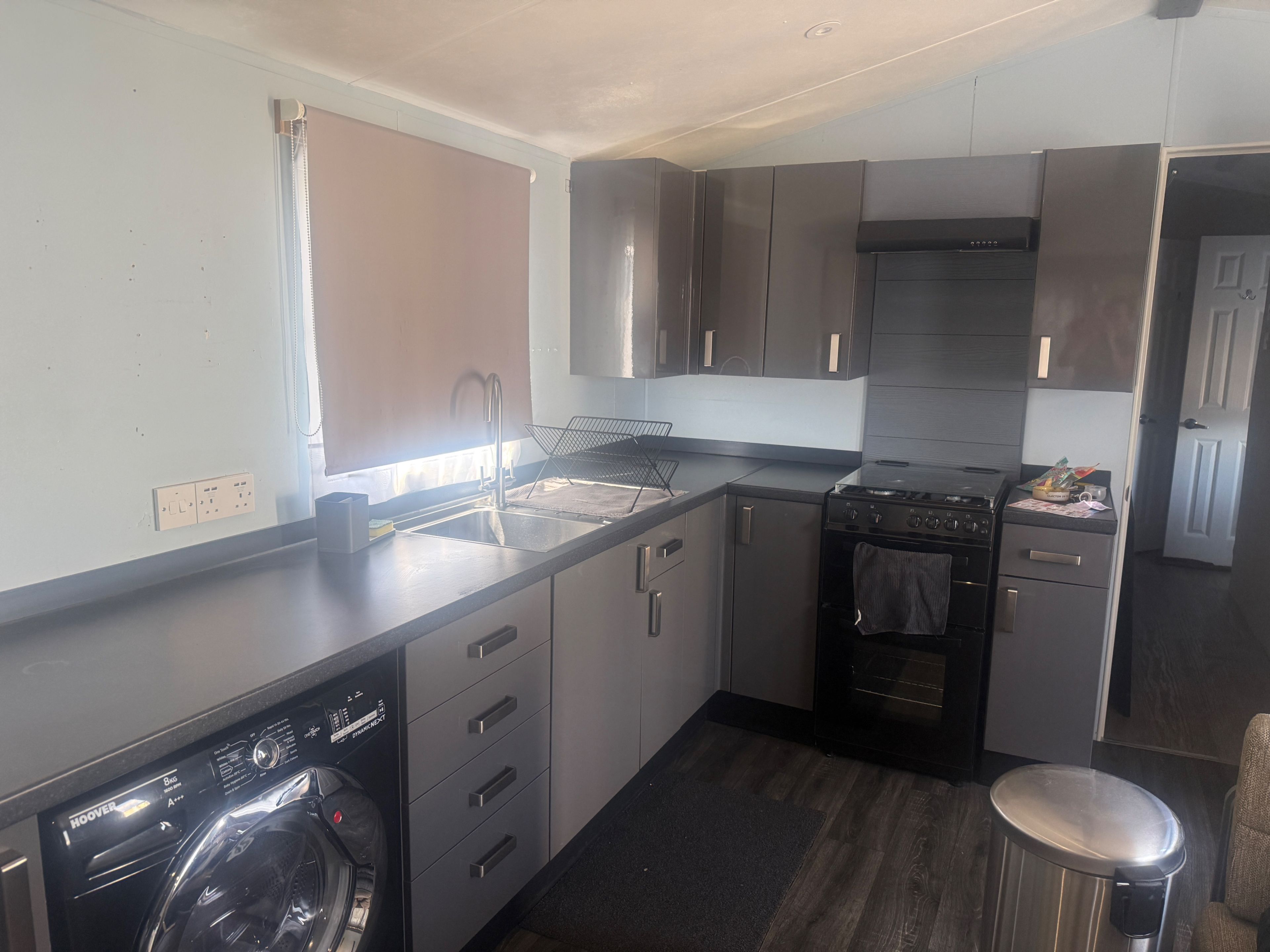 A compact kitchen with a built-in washer, a stove, and a sink.