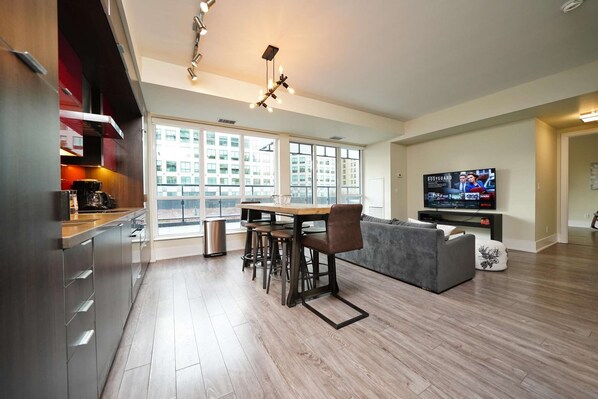 A modern apartment with a kitchen, dining area, and living room. - The Atmos by RivetStays – Spacious 2BR Downtown Condo (Toronto)