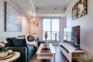 Un salon moderne avec un canapé, une table basse et un téléviseur à écran plat.