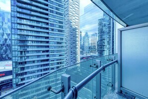 Un edificio de gran altura con fachada de vidrio moderna, barandilla metálica y vistas despejadas de la ciudad.