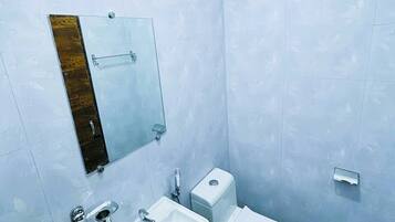 Un baño con lavamanos, inodoro y espejo.
