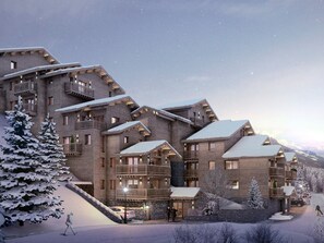 A multi-story hotel with balconies and a ski slope in the background. - Family apartment with mountain view (Méribel)