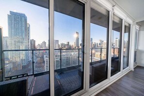 Ein Hochhausapartment mit großen, raumhohen Fenstern und Blick auf die Stadtlandschaft.