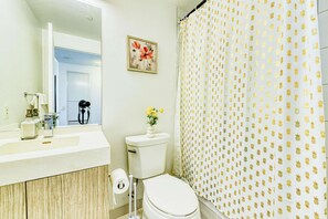 Une salle de bain avec des toilettes, un lavabo et un rideau de douche.