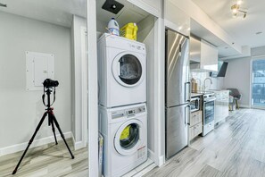 A modern kitchen with stainless steel appliances, a built-in oven, and a large window. - RivetStays | The Jarvis Business Suite – Downtown Studio Suite (Toronto)