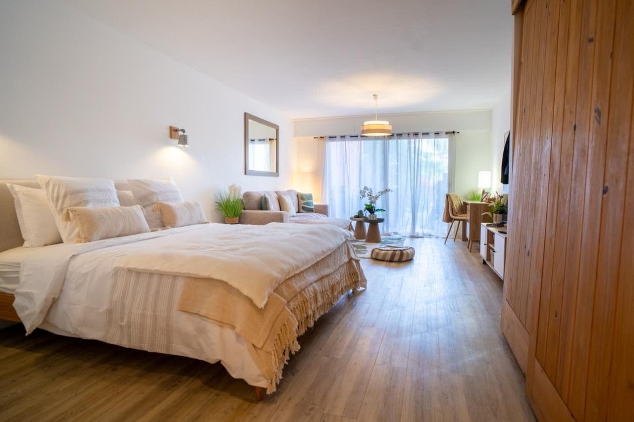 A bedroom with a large bed, bedside tables, a desk, and a chair.