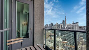 A balcony with a view of a city skyline, including a prominent tower.