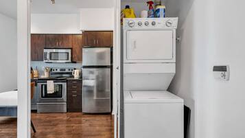 A compact kitchen with a microwave, oven, and refrigerator.
