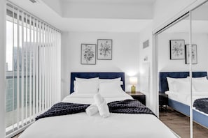 Ein Schlafzimmer mit einem Bett, einer Nachttischlampe und gerahmten floralen Bildern an der Wand.