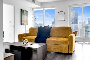 Un salon moderne avec un canapé, une table basse et un tableau accroché au mur.