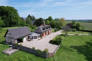 A large, single-story building with a gravel driveway and a fenced garden area. - Cottage 'Le Gîte Du Bois Du Fil' 1km from GR210 (Vassonville)
