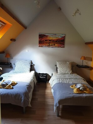 A bedroom with two beds, a painting on the wall, and a suitcase on the floor. - Cottage 'Le Gîte Du Bois Du Fil' 1km from GR210 (Vassonville)