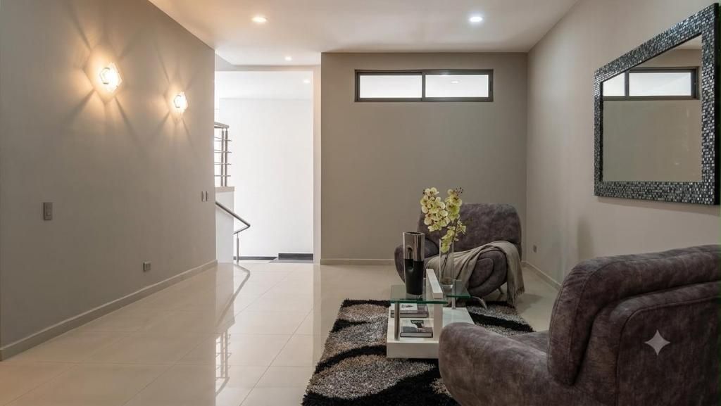 Una sala de estar moderna con un sofá, una mesa de centro y un jarrón decorativo.