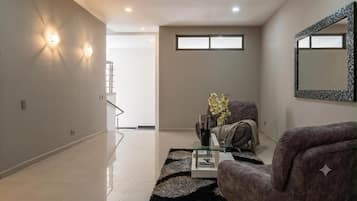 Una sala de estar moderna con un sofá, una mesa de centro y un jarrón decorativo.