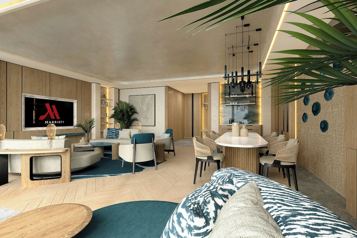 A modern living room with a sofa, coffee table, and dining area with chairs.