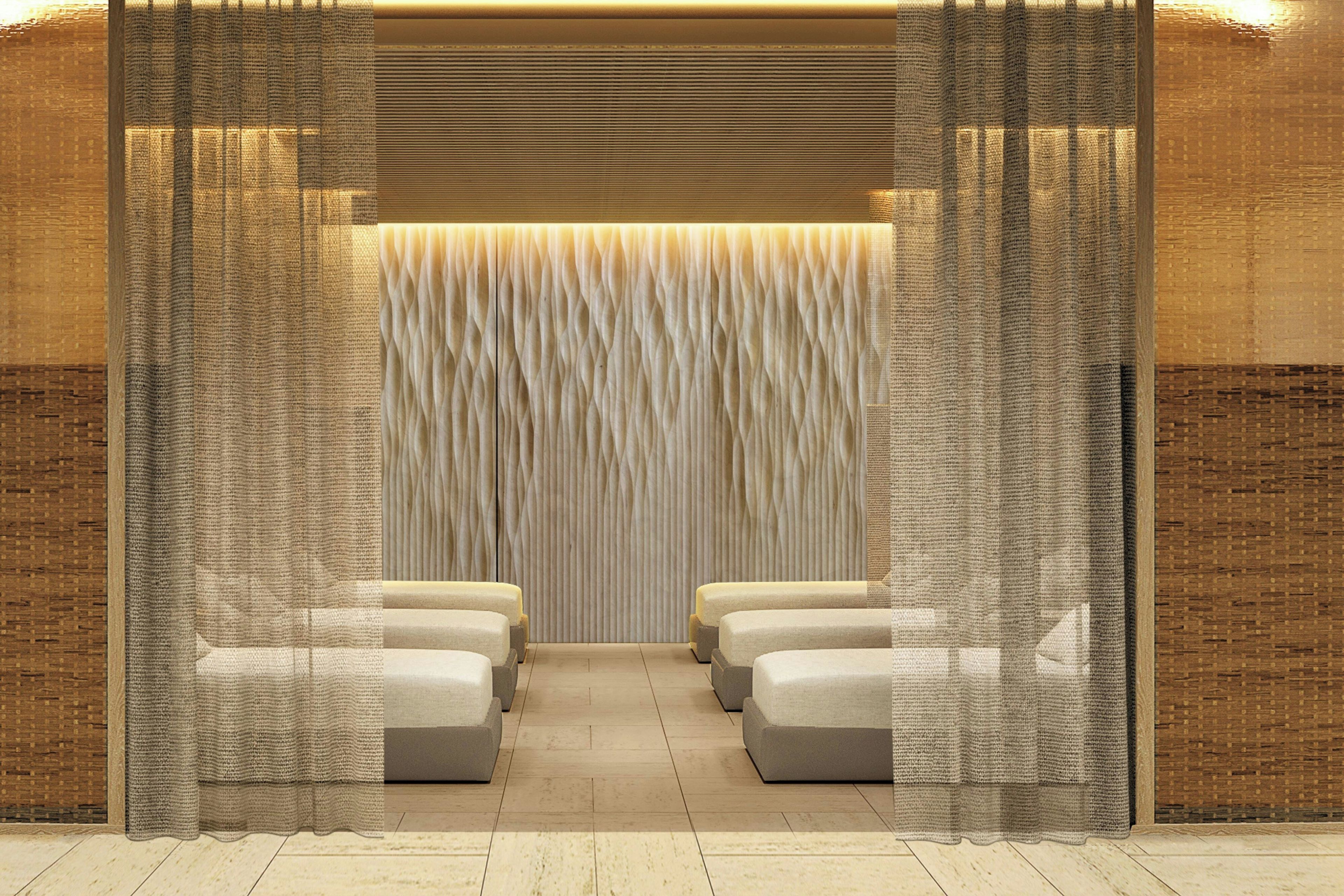 A room with a seating area featuring cushioned benches and a textured wall.