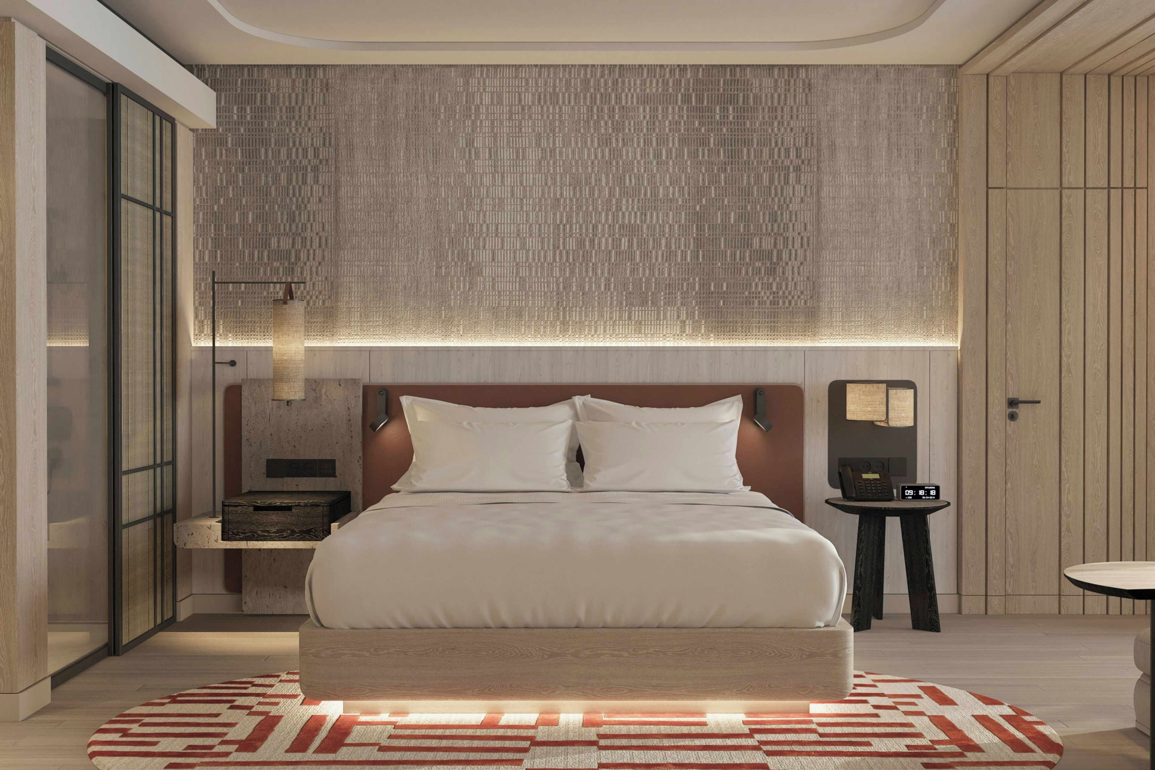 Une chambre d’hôtel moderne avec un grand lit, une table de chevet, une commode, un téléphone fixé au mur et une horloge numérique.