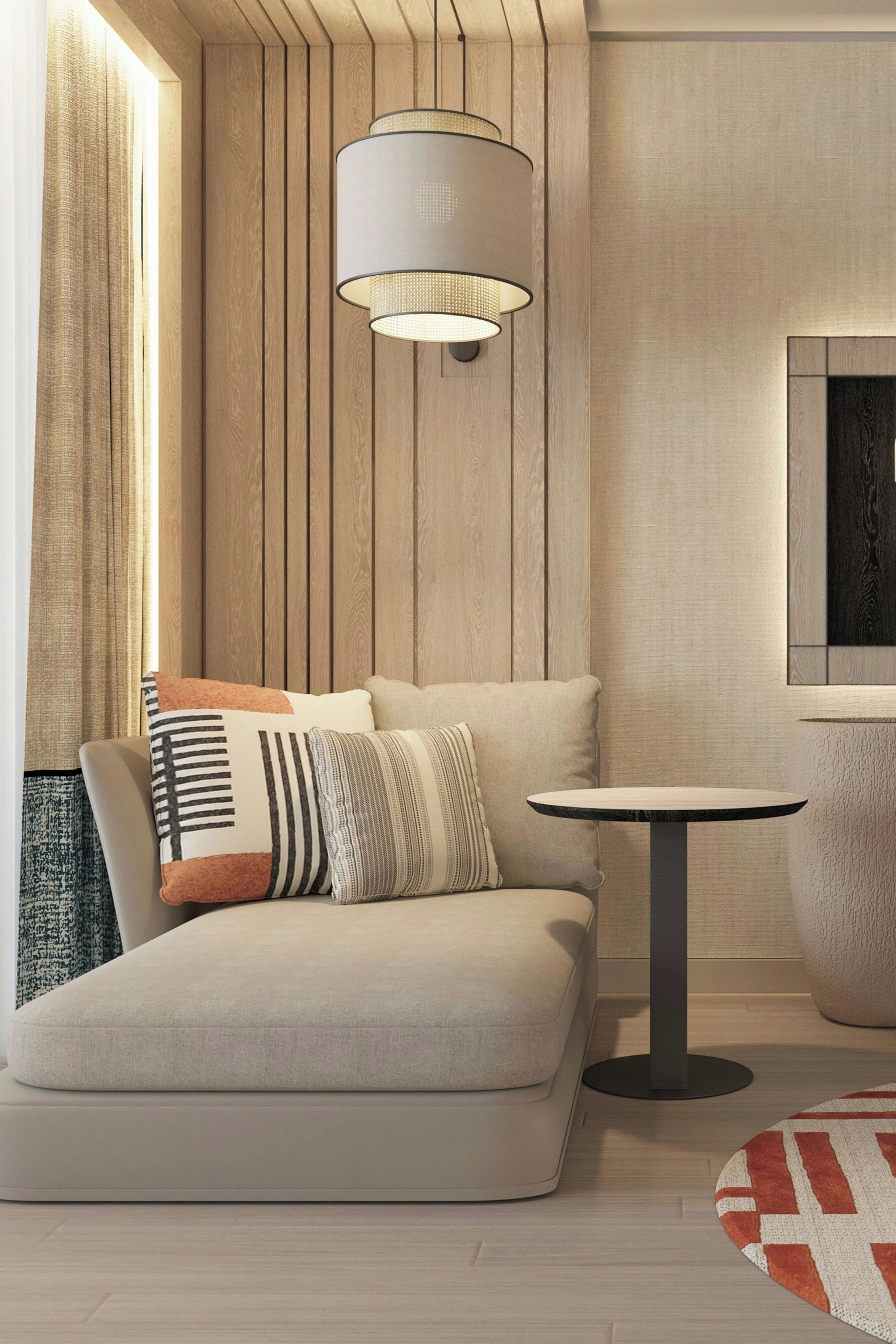 Un salon moderne avec un canapé, une table ronde et un luminaire suspendu.