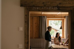 Un interior de madera con una ventana, un banco y una mesa con bebidas.