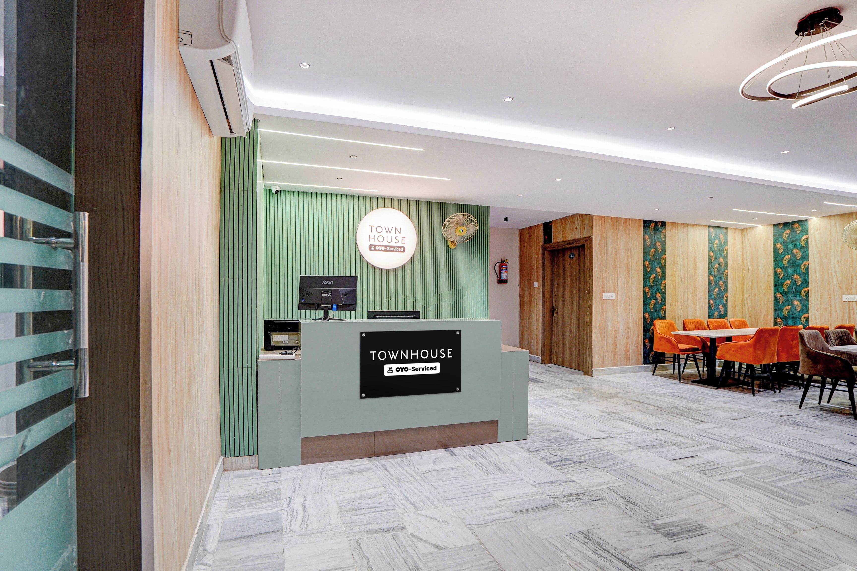 A reception desk with a sign indicating 'Town House' and 'OYO-Serviced'.