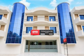 Un hotel con fachada moderna, destacando un cartel llamativo para OYO TOWNHOUSE HOTEL.