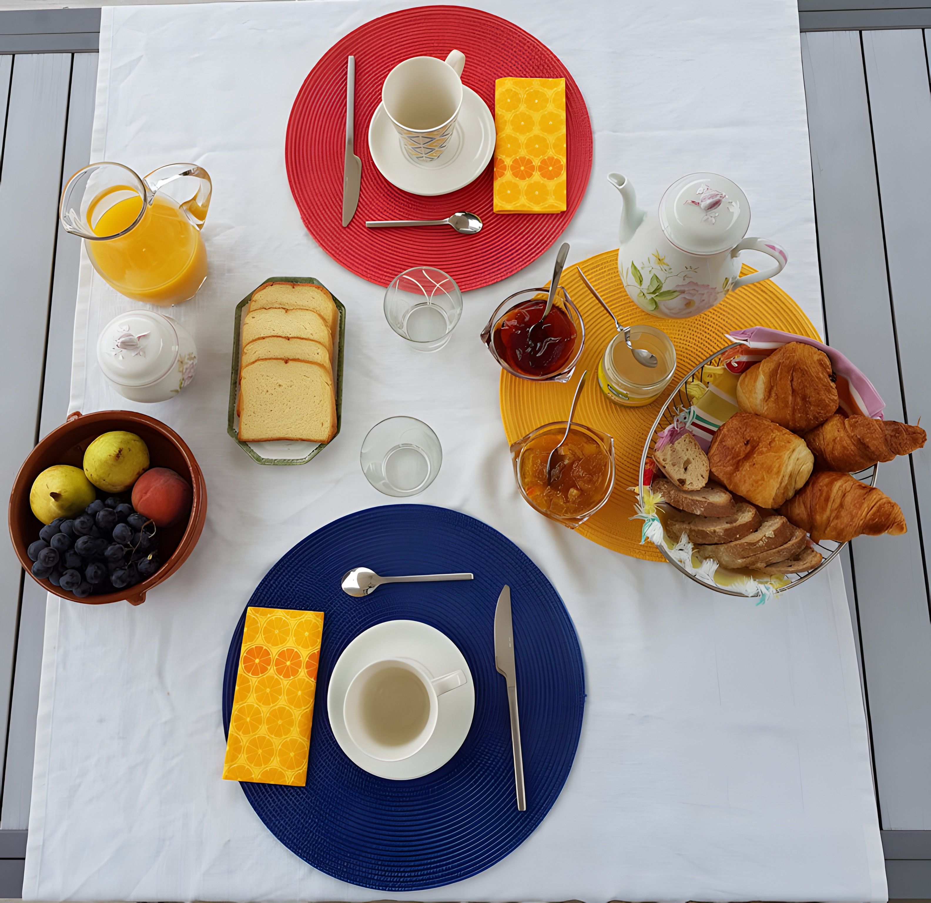 En morgenmadsopsætning med forskellige spiser og drikkevarer på et bord.