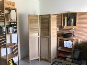 A room with a wooden wardrobe, a sink with a basin, and a mirror. - Bed and Breakfast 'Le Pas Des Chevreuils' with Wi-Fi (Salles)