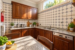A kitchen with wooden cabinets, a granite countertop, a sink, and a dishwasher. - Frontemura House with a Terrace (Lucca)