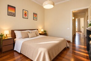A bedroom with a large bed, two bedside tables with lamps, and three framed artworks on the wall. - Frontemura House with a Terrace (Lucca)