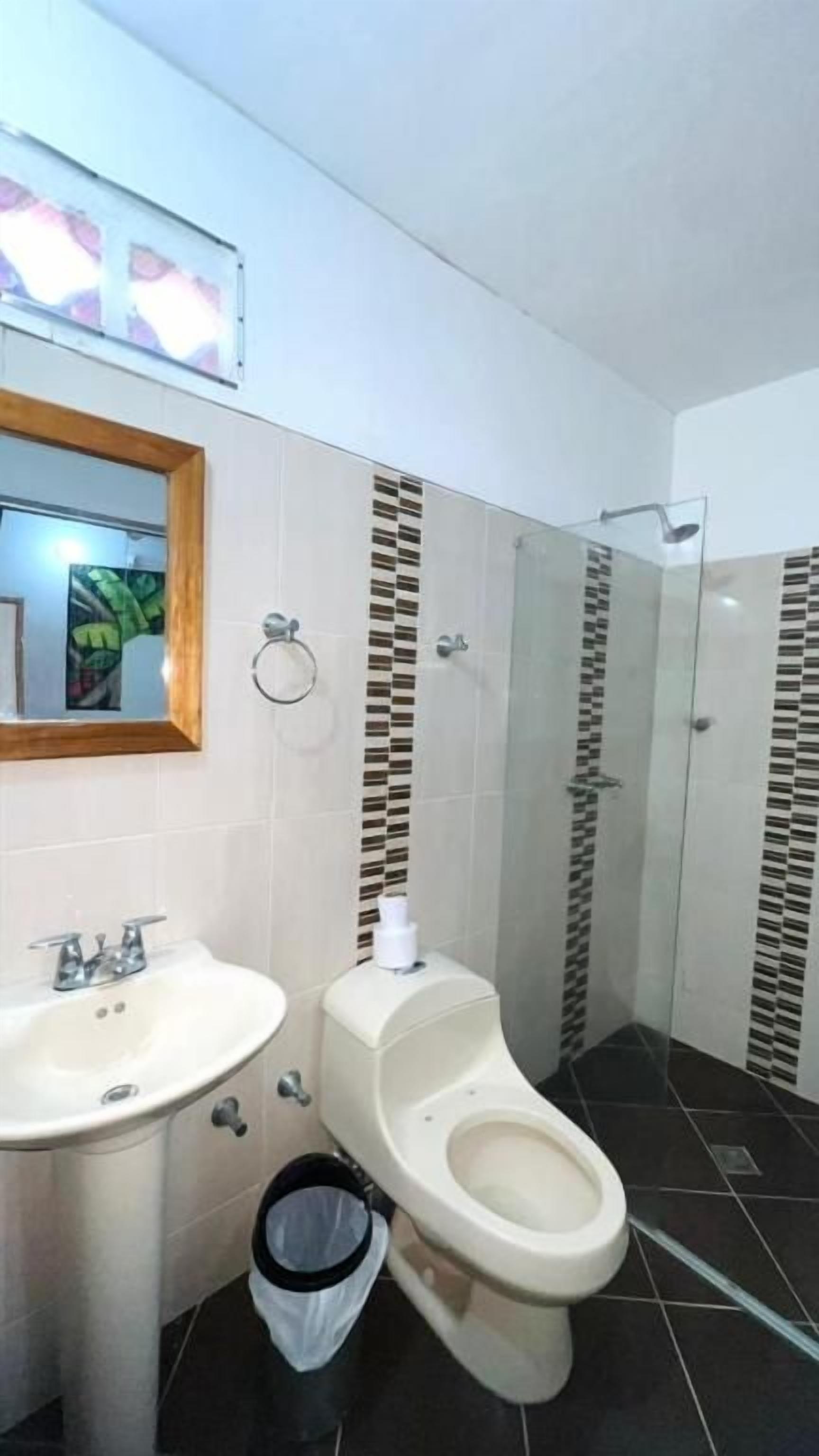A bathroom with a sink, toilet, and shower area.