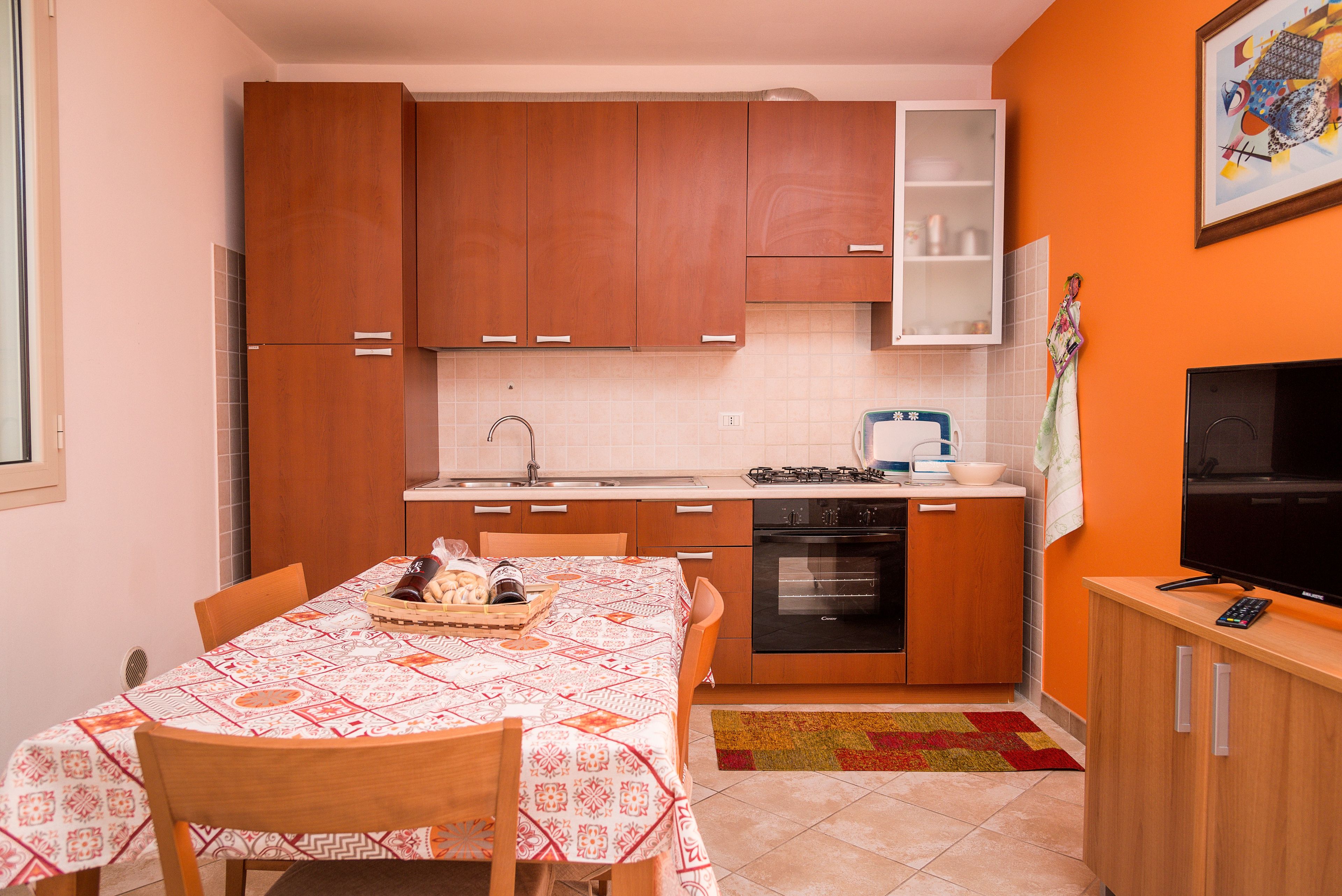 Una cocina compacta con armarios de madera, estufa a gas, horno y microondas.