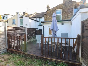 A wooden deck with a railing, a table, and a chair. - Gillingham House (Gillingham)