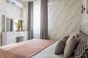 A bedroom with a bed, a dresser, a mirror, and a window with curtains. - Apartments Zarafshan city 151 Tashkent (Tashkent)