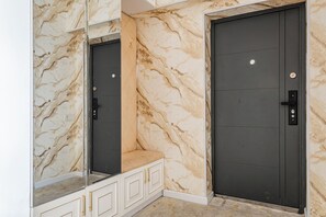 A room with marble walls, a bench, and two doors. - Apartments Zarafshan city 151 Tashkent (Tashkent)