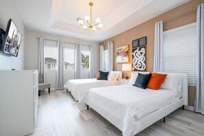 A hotel room with two beds, a chandelier, artwork on the wall, and a window with blinds. - 6BR Sonoma Resort Home Pool & Cars Game Room (Kissimmee)