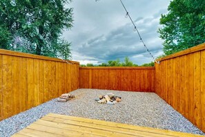Eine Holzterrasse mit Kiesfläche und einem Holzstapel.