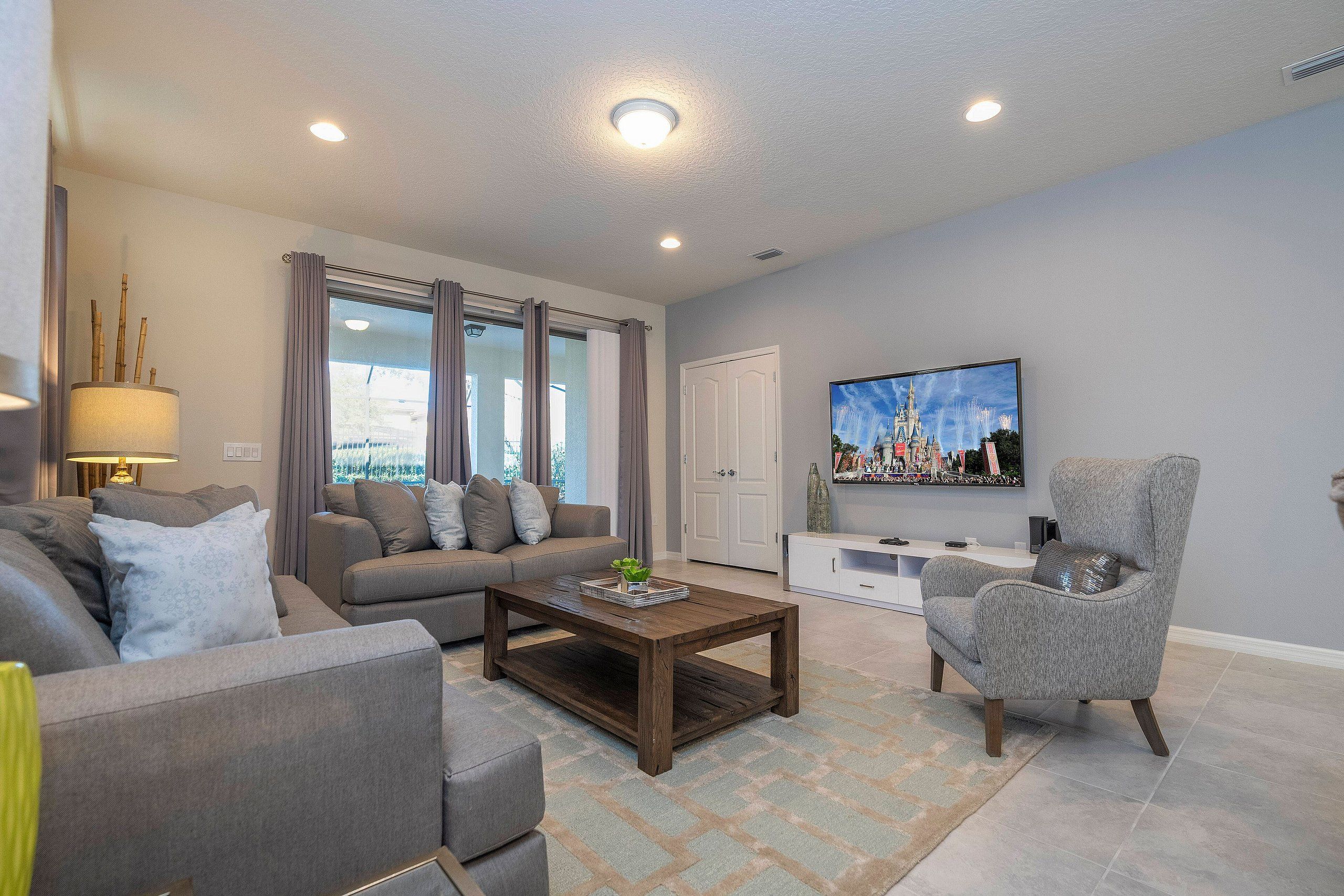 A modern living room with a sofa set, a coffee table, a TV, and a fireplace.