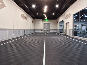 Un vaste espace intérieur doté d’un sol à carreaux, d’une allée centrale et d’un mur miroir sur l’un des côtés.