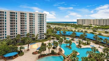 A resort with multiple swimming pools, palm trees, and beachfront views.