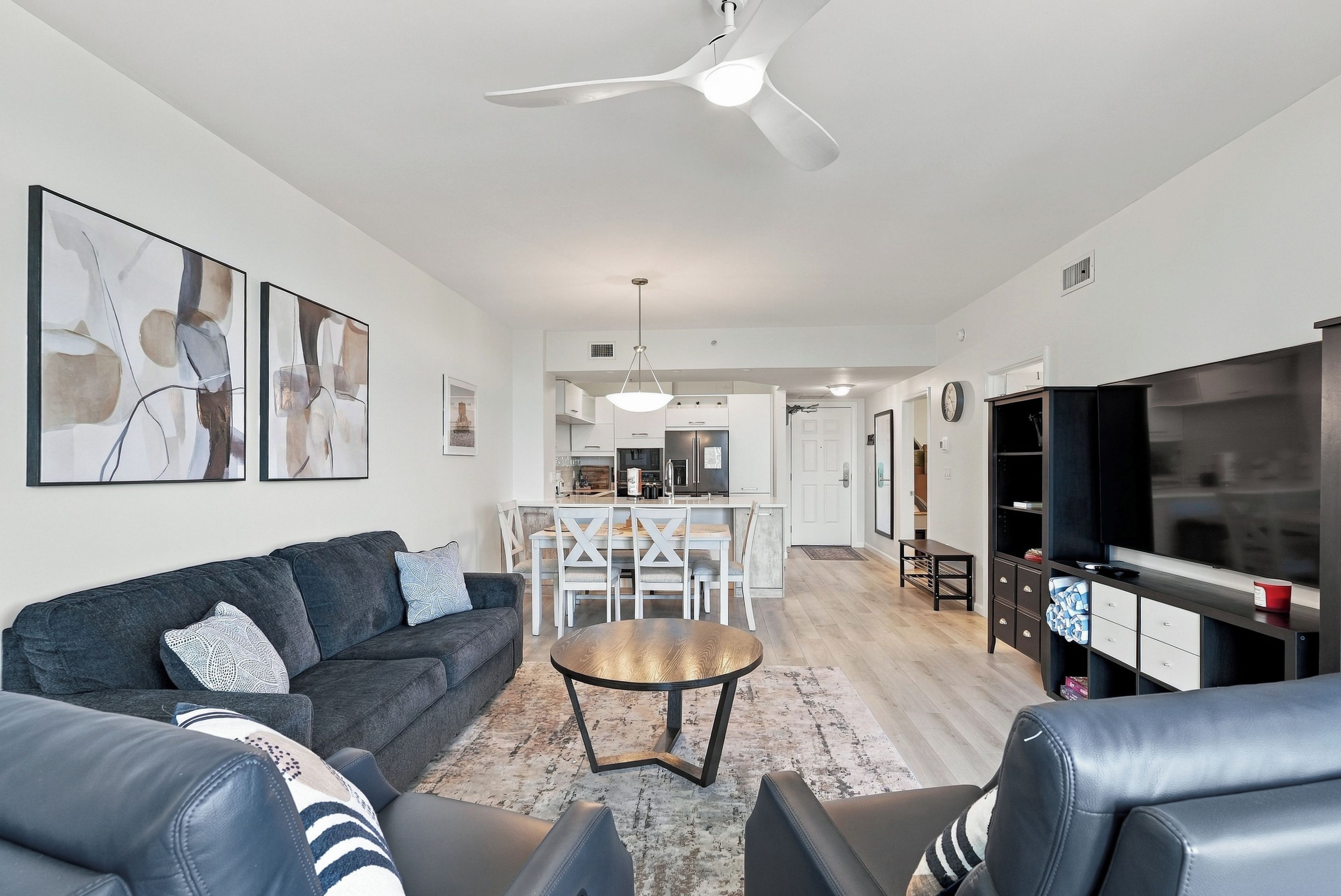 A modern living room with a sofa, coffee table, and TV stand.