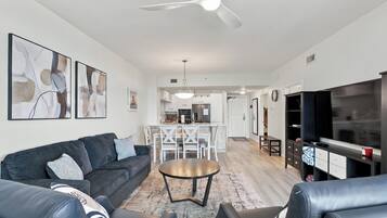 A modern living room with a sofa, coffee table, and TV stand.
