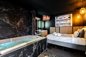 A modern bathroom with a marble vanity, a bathtub, and a shower.