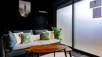 A modern interior with a sofa, pillows, a coffee table, and a plant.