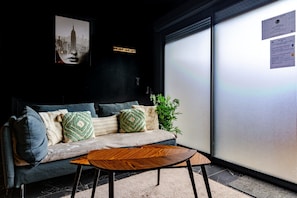 Un interior moderno con un sofá, almohadas, una mesa de centro y una planta.