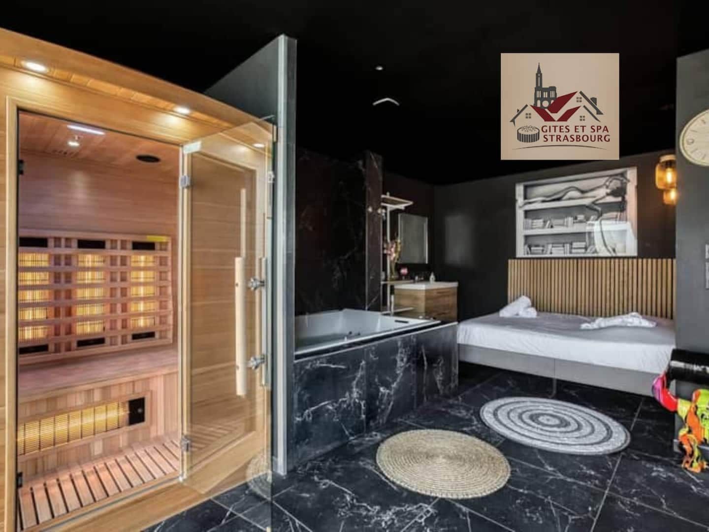 Een moderne hotelkamer met een sauna, een groot bed, een badkamer met ligbad en een wandklok.