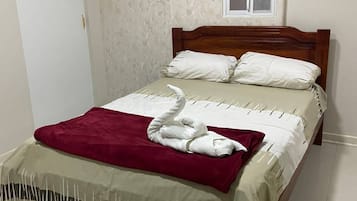 A bed with a wooden headboard, white bedding, and a red blanket.