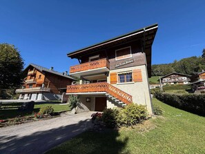 A two-story wooden chalet with a balcony and a staircase leading to the upper floor. - Peaceful family chalet - 6 guests (Les Gets)